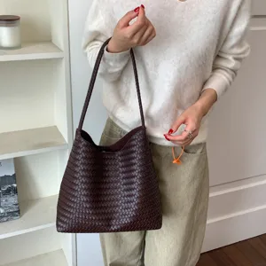 Close-up view of the dark brown woven leather shoulder bag, showcasing fine texture and details.