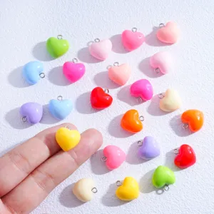 Primer plano de colgantes de corazón de resina colorida, accesorios de joyería DIY.