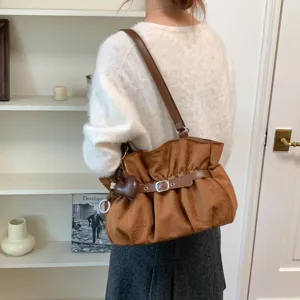 Vista dettagliata della elegante borsa a tracolla marrone con trama morbida e stile.