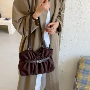 Dettaglio borsa a spalla in camoscio marrone, design tote morbido con elegante fibbia chic.