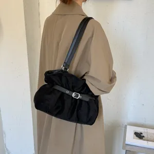 Vista dettagliata della borsa a spalla nera alla moda in camoscio con cinturino con fibbia.