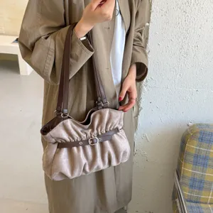 Dettaglio ravvicinato della borsa a tracolla casual in camoscio sintetico con elegante design plissettato.