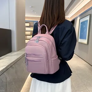 Pink leather backpack detail showing multiple front zipper pockets and casual style.