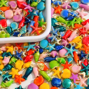 Vista detallada de dijes coloridos de aleación esmaltada con forma de estrella de mar y concha.