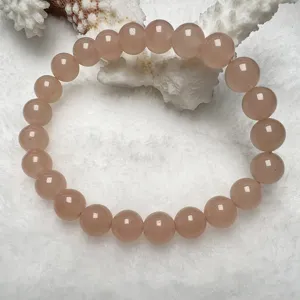 Exquisite pink quartz gemstone bracelet detail, smooth round beads shining gracefully.