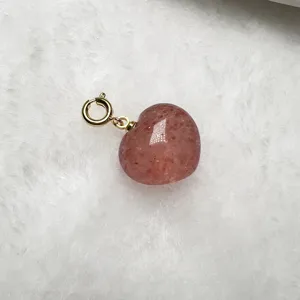 Primer plano detallado de un colgante de cuarzo fresa natural con cierre de resorte dorado.