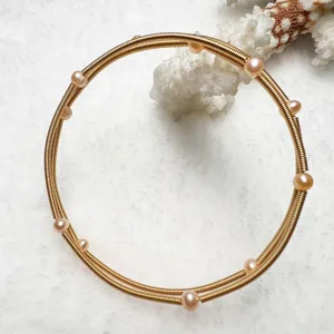 Multi-layer golden wire bracelet with pink freshwater pearls elegant wrist jewelry for women.