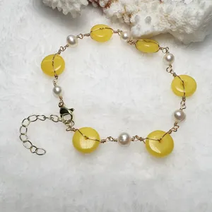 Detalle de pulsera de perlas de jade amarillo hecha a mano con fino alambre artesanal.