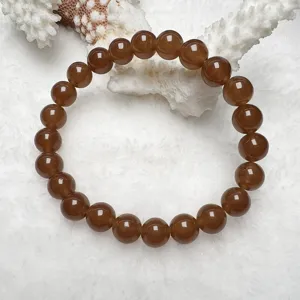 Brown quartzite jade bead bracelet detail view, smooth polished round beads close up.
