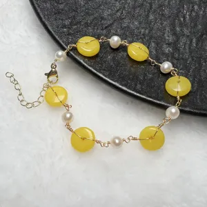 Pulsera artesanal de alambre con perlas de agua dulce y piedras amarillas. Vista detallada.