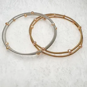 Natural freshwater pearl multi-layer memory wire bracelet set in silver and gold colors.