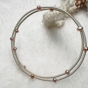 Detailed view of the multi-layer silver wire bracelet featuring elegant pink freshwater pearls.