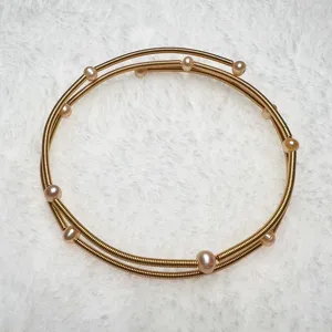 Multi-layer spring gold bracelet adorned with small freshwater pearls for women chic style.