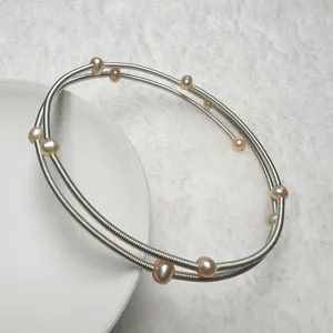 Detail view of multi-layer pearl bracelet with pink freshwater pearls on silver wire.