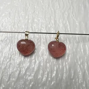 Primer plano detallado de colgantes de cuarzo fresa natural en forma de corazón con ganchos.