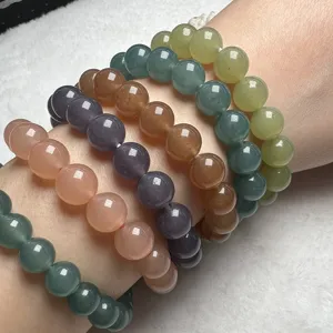Detailed close-up shot of colorful round bead bracelets stacked on wrist, smooth texture.