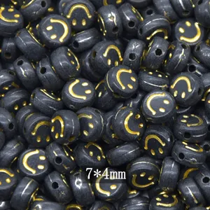Black acrylic flat beads with gold smiley face pattern, perfect for DIY jewelry making 7x4mm.