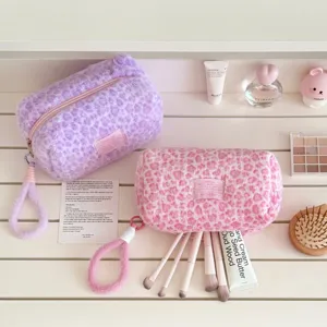 Fluffy leopard print cosmetic bag and pencil case with plush wrist strap, ideal for travel.