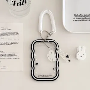 Close-up of transparent wavy card holder detail with white spring strap and cute ghost pendant