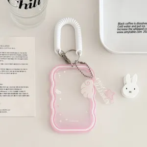 Transparent pink card holder keychain with coil spring strap and cute angel wing star pendant.