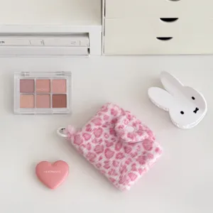 Pink fuzzy leopard coin purse detail, cute plush earphone bag and card holder flat lay view.