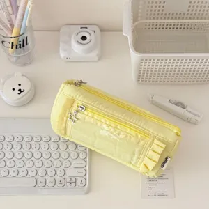 Close-up view of a stylish yellow ruffled pencil case with transparent window and zipper.