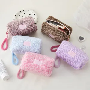 Plush leopard print cosmetic bag detail showing soft fluffy texture and cute zipper pull.