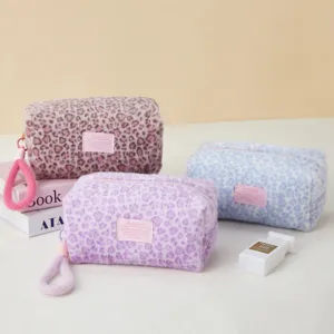 Plush leopard print cosmetic bag and pencil pouch detail view with cute pink label and strap.