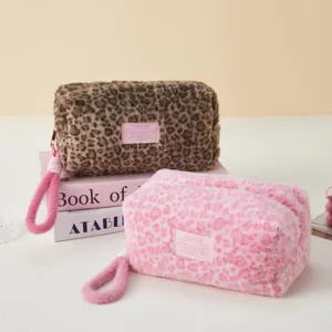 Detailed view of fluffy leopard print cosmetic pouch with soft plush texture and cute handle.