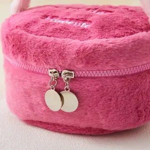 Cute pink plush round cosmetic bag detail, soft fluffy fabric with metal dual zipper pulls.