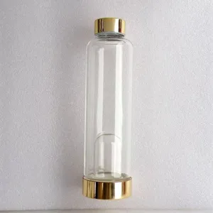 Transparente Kristall-Energie-Glasflasche mit eleganten goldenen Metalldeckeln.