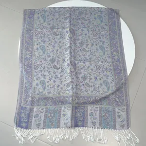 Close-up detail of ethnic style paisley jacquard shawl with delicate white tassels
