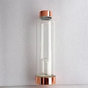 Detailansicht einer Glaswasserflasche mit roségoldenen Kappen und interner Kristallkammer.