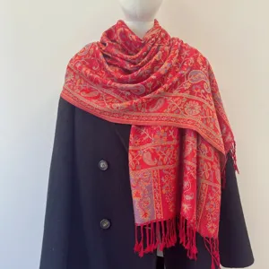 Detailed macro view of red ethnic paisley jacquard pashmina with elegant tassels