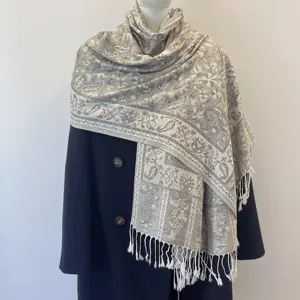 Detail shot of an ethnic style paisley jacquard shawl with decorative white fringe tassels