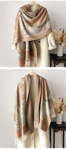 Nahaufnahme eines vintage Ethno-Schals mit Blumenmuster und Fransen an einem hellen Mantel
