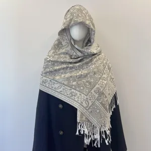 Detailed view of ethnic paisley jacquard pattern on a beige tassel shawl