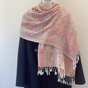 Close-up of ethnic paisley jacquard scarf with tassels on a black coat