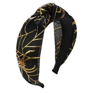 Close-up of black knotted headband with gold spider web pattern for Halloween