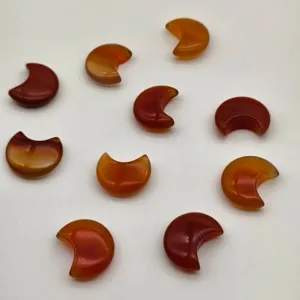 Vista dettagliata di vari ciondoli a forma di luna in agata rossa per gioielli fai da te.