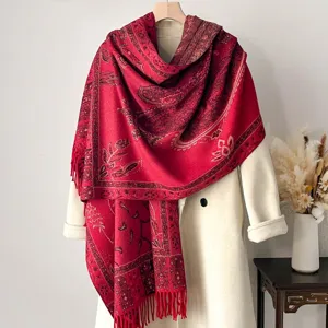 Eleganter ethno-floraler Jacquard-Schal mit Fransen auf einem klassischen weißen Mantel