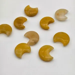 Primo piano di ciondoli in pietra naturale gialla a forma di luna per la creazione fai-da-te.