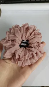 Primo piano del fermaglio per capelli in rete rosa plissettata con design in chiffon tondo
