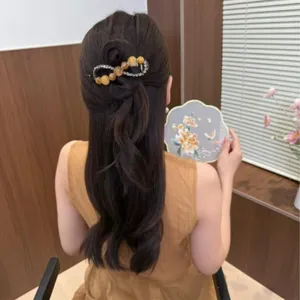 Primo piano della molletta per capelli con strass e perline sul retro, stile elegante.