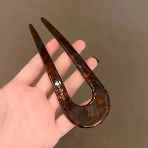 Detailed close-up view of a vintage tortoiseshell U-shaped hair fork for elegant buns.