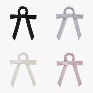 Detailed view of fabric bow hair scrunchies in four classic colors, stylish hair accessories.