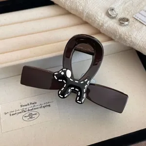 Primo piano dettagliato dell'elegante molletta per capelli marrone scuro con simpatico cagnolino.