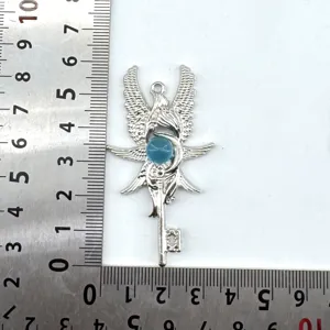 Detailopname van vintage engelen vleugel sleutel hanger met blauwe steen, diy sieraden.