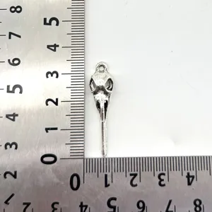 Details of vintage zinc alloy bird skull pendant, showing size with scale rulers clearly.