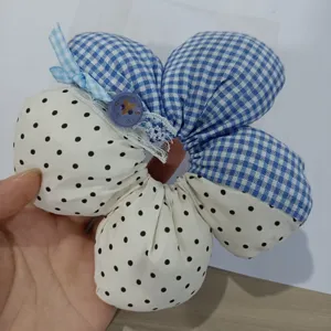 Close-up detail of cute plaid and polka dot fabric hair scrunchie with sweet blue bow.
